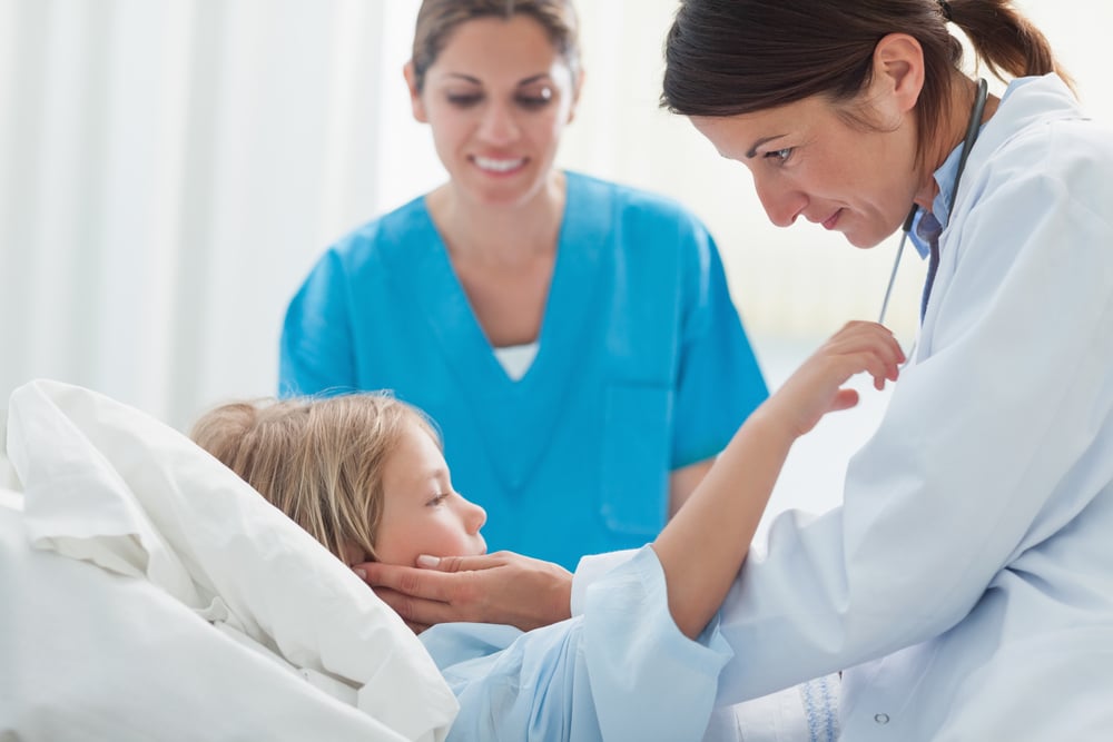 Doctor touching a child in hospital ward