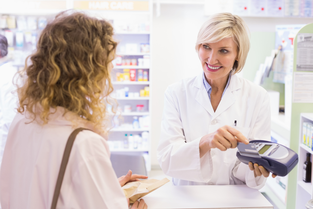 Pharmacist using card machine at pharmacy